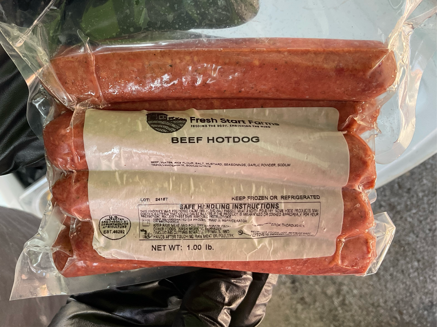 Packaged all-beef hotdogs in a plastic bag with the brand 'Fresh Start Farms' labeled on the packaging.